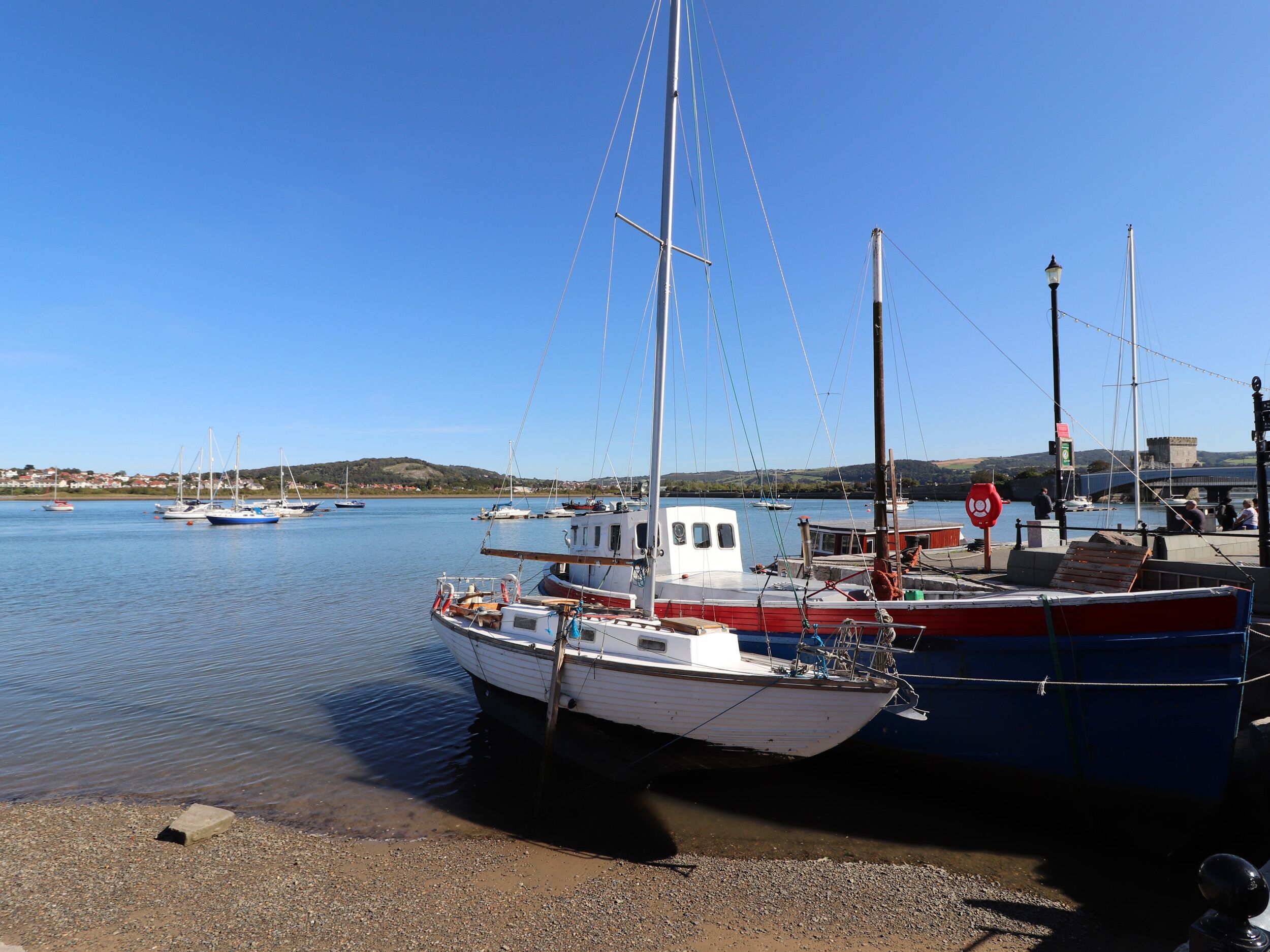 Un puerto con barcos amarrados, agua tranquila y cielo despejado.