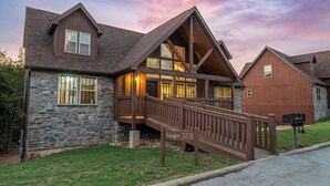 Un chalet à la façade en pierre, doté d’une terrasse en bois et d’une enseigne indiquant « Chalet 126 ».