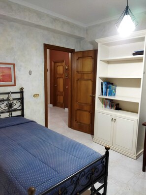 Une chambre à coucher avec un lit, une armoire et une bibliothèque.