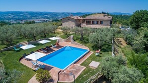 A large swimming pool with a stone deck, surrounded by a well-maintained lawn and several lounge chairs. - Le Residenze dei Potti 12, Emma Villas (Pantalla)
