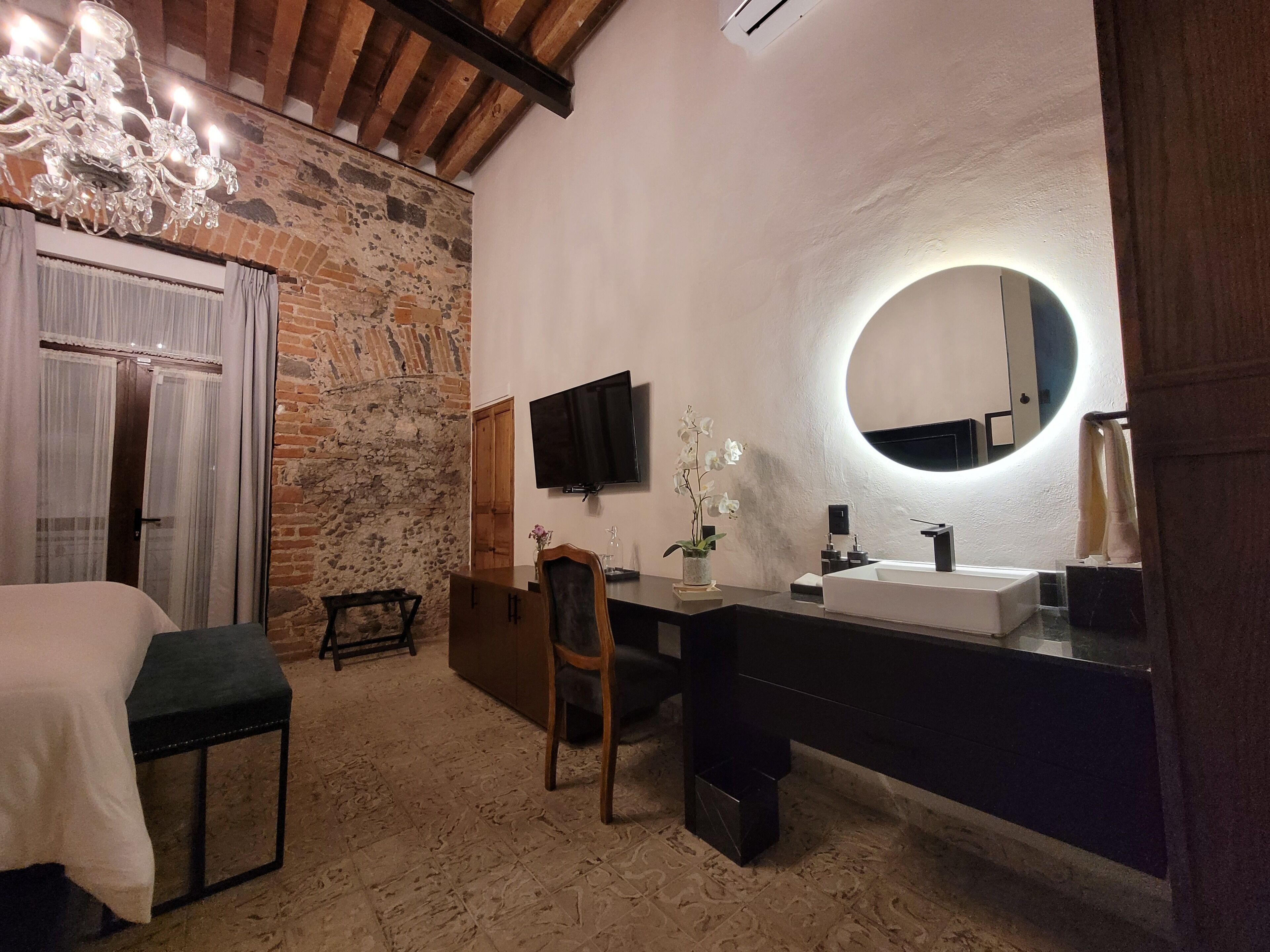 A modern bathroom with a large mirror, a sink, and a shower area.