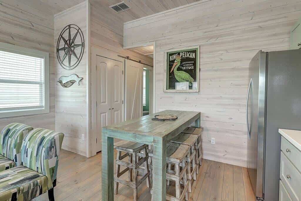 Eine Küche mit Holzwänden, einem Holztisch und einem Kühlschrank.