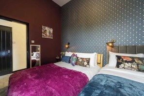 Ein Hotelzimmer mit einem großen Bett, einer Wand mit Muster und einer Tür, die auf einen Balkon führt.