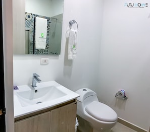 Bathroom features a sink, toilet, shower, and cabinet for storage.