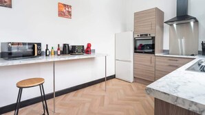 Eine moderne Küche mit Mikrowelle, Kaffeemaschine und Backofen.
