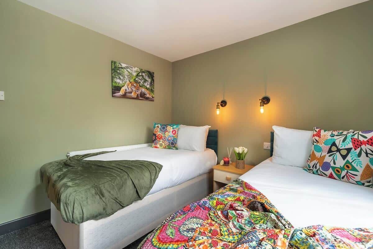 Een hotelkamer met twee bedden, een schilderij aan de muur en twee wandlampen.