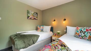 Een hotelkamer met twee bedden, een schilderij aan de muur en twee wandlampen.