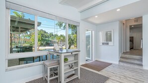 Un intérieur moderne avec un bureau, des étagères et une vue sur l’extérieur.