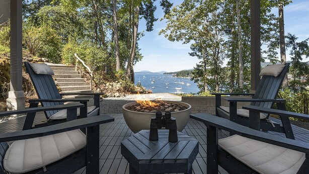 Un espace extérieur aménagé avec deux fauteuils Adirondack et un foyer.