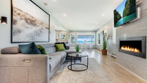 Un salon moderne avec un canapé, une table basse et une cheminée.