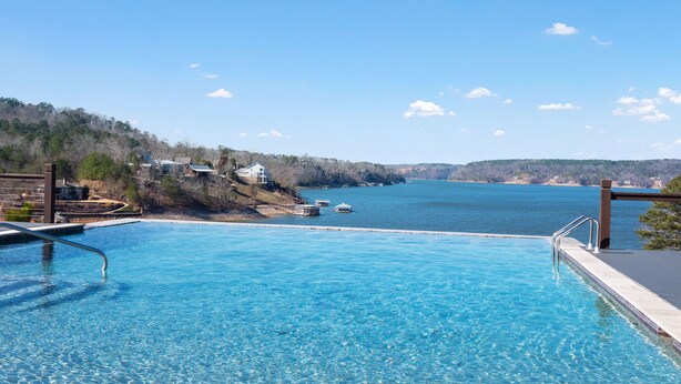 A clear blue pool with a view of a lake and distant hills. - Mallard Pointe 100 - Luxury condo- conveniently located! (Cullman)