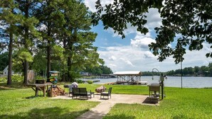 A lakeside park with picnic tables, chairs, and a covered pavilion. - Rest-Relax-Refresh (Waterloo)