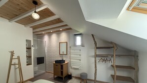 A bedroom with a bed, a wooden ladder, a dresser, a mirror, a hanging rack, and a skylight. - Gite DU Chene - Ledeuix (LEDEUIX)