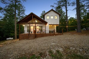 A two-story house with a wooden deck and a covered porch. - Fleur de Lake- 2 King Bedrooms w/ Loft & Hot Tub- Minutes from State Park (Broken Bow)