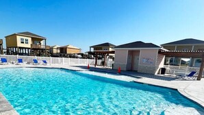 A rectangular swimming pool with clear blue water, surrounded by a white fence and a paved deck. - Gorgeous Beach House w/Pop Up Bar & Community Pool (Rockport)