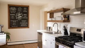 Een moderne keuken met een prikbordmenu waarop ontbijt, lunch, diner en weekendbrunch staan aangeboden.