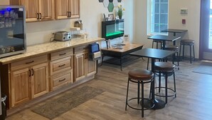 A modern kitchen with wooden cabinets, a large island, and a mounted deer head. - The Fireside Inn (Long Beach)