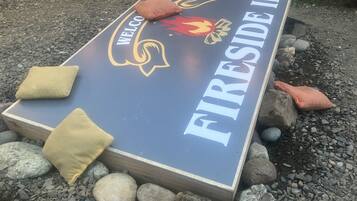 Un cartello di benvenuto per Fireside Inn, con il logo di una fiamma e un'accogliente area salotto con cuscini.