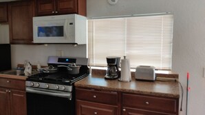 A compact kitchen with a stove, microwave, refrigerator, and a window with blinds. - A newly remodeled 1BD&1BR private whole Guest-home to yourself! (Lancaster)