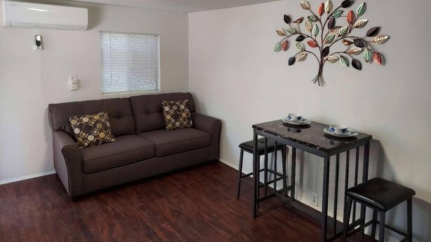 A living room with a brown sofa, patterned cushions, a small table with two stools, and a decorative wall piece. - A newly remodeled 1BD&1BR private whole Guest-home to yourself! (Lancaster)