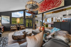 A modern living room with a large window, a fireplace, and a view of the outdoors.