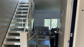 A staircase leading to a living area with a sofa and a coffee table. - The Spacious Canal Condo (Caseville)