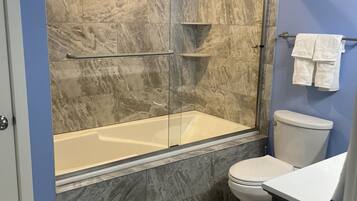 Combined shower/bathtub, towels, toilet paper
