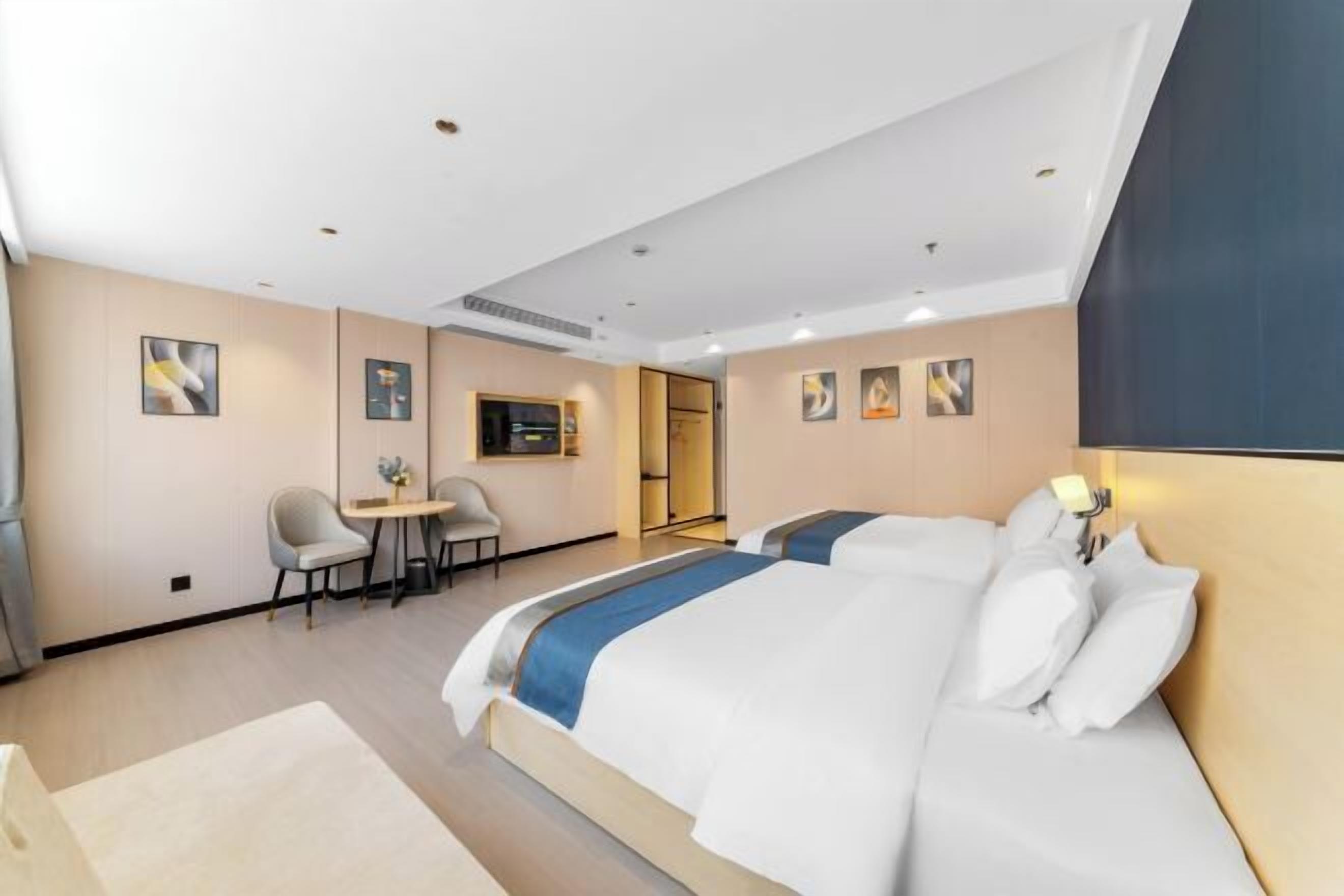 A modern hotel room with a large bed, a desk, and a chair.