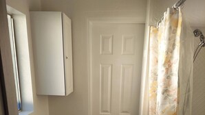 A bathroom with a toilet, sink, cabinet, and shower curtain.