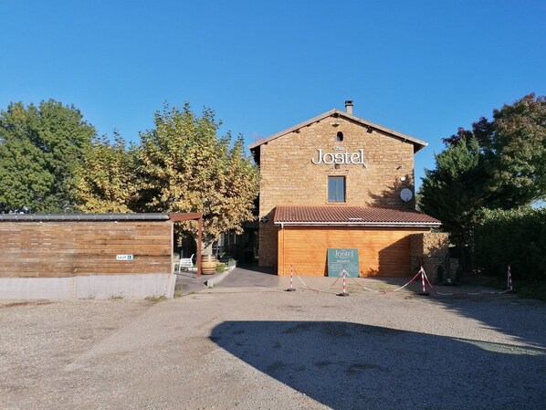 A two-story building with a sign reading "Jostel" and a smaller sign below it indicating a restaurant.