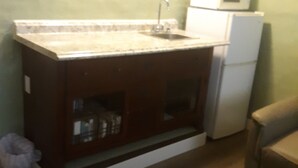 A compact kitchen with a built-in sink, a microwave, and a refrigerator. - Magnolia Gallery & Inn - lodging in an 1864 building in a living  ghost  town. (Austin)