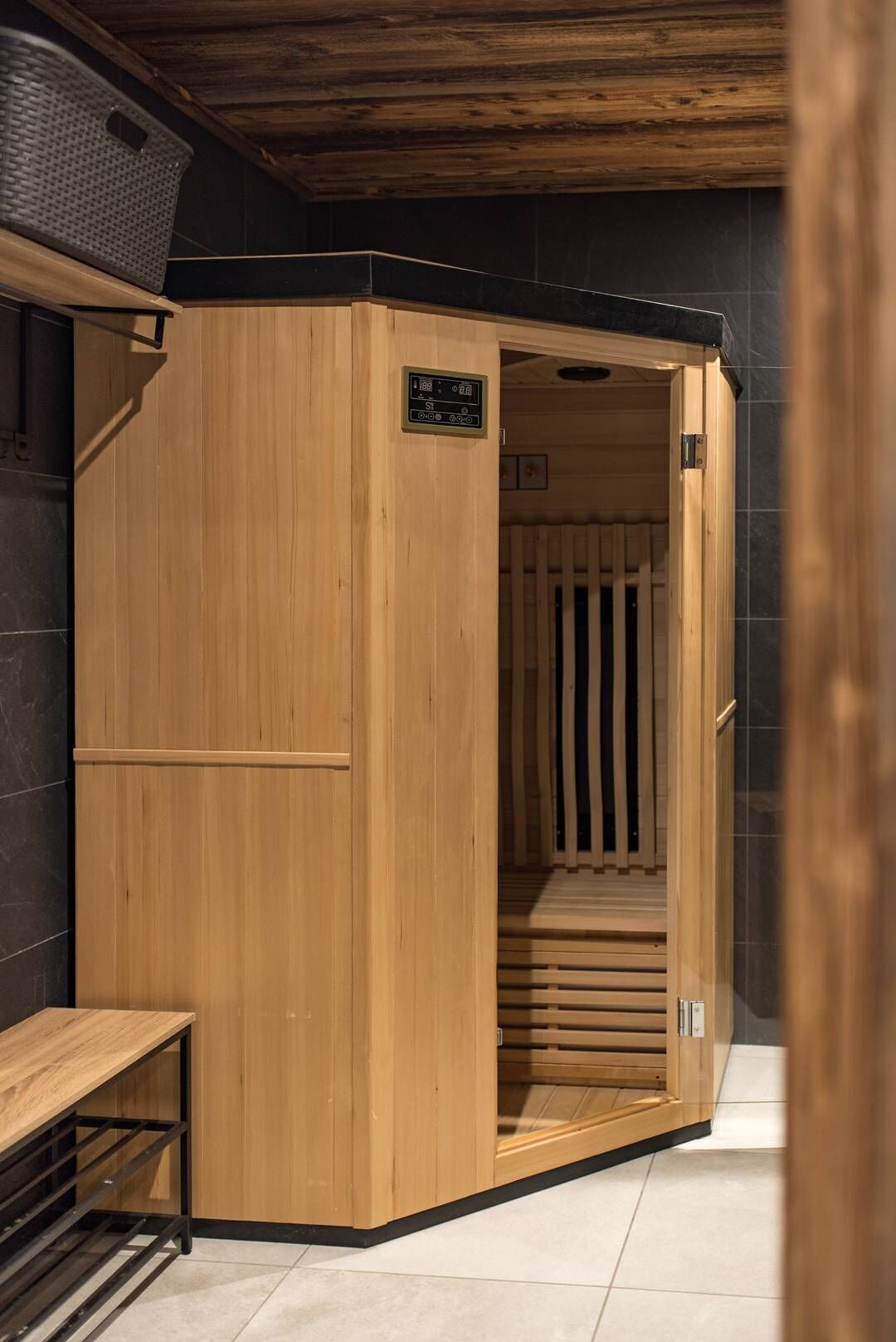 A sauna with a wooden interior, a bench, and a tiled floor.
