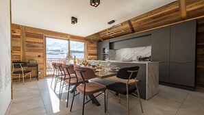 A modern kitchen with a marble backsplash, wooden accents, and a view of mountains. - Olvera 501 - New apartment on the slopes (VALMEINIER)
