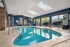 A swimming pool with a clear blue water, surrounded by a room with blue walls and large windows. - LUXE Cabin * Stunning Views * Heated Pool * Sauna * Hot Tub * Location (Gatlinburg)