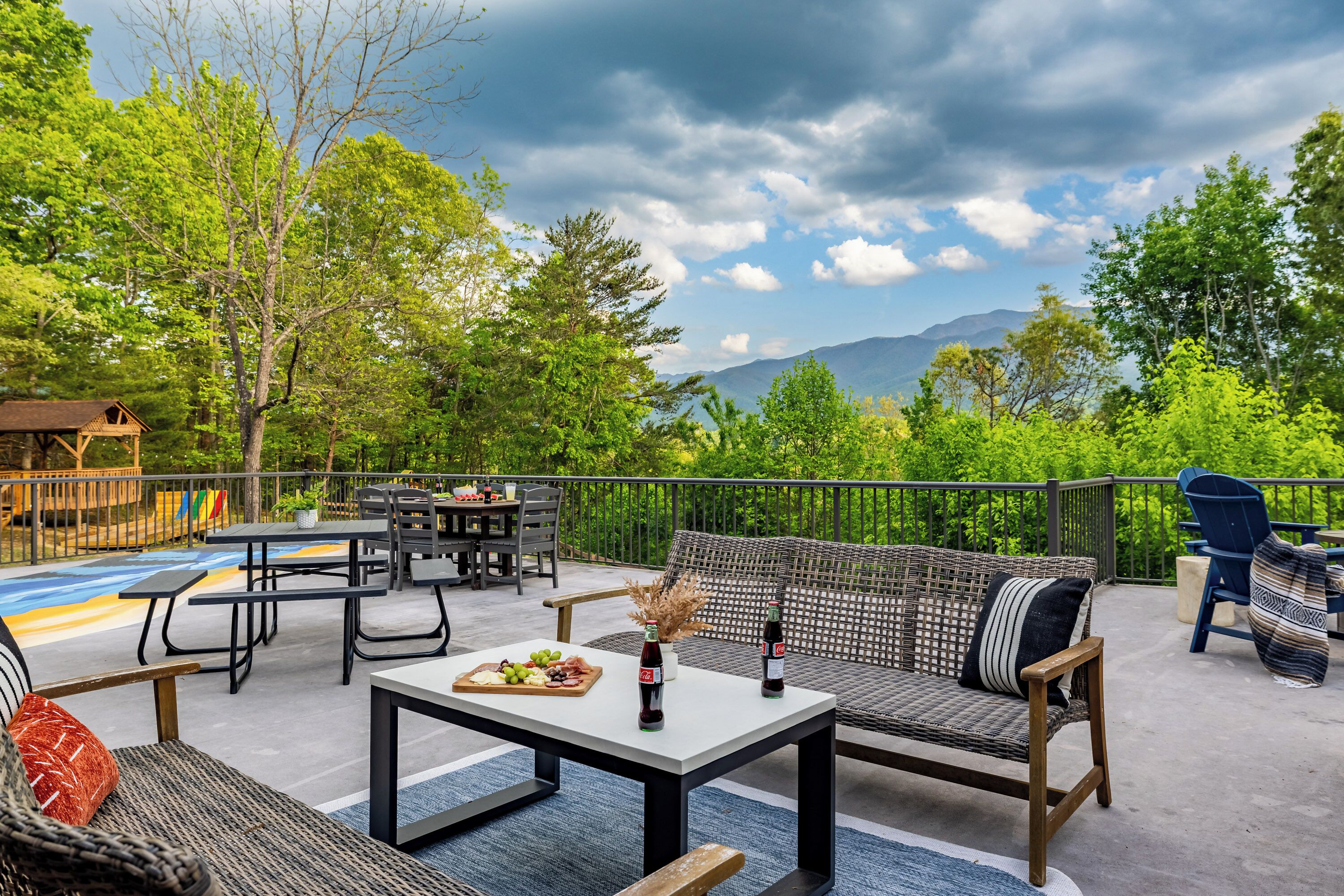 An outdoor patio with seating, picnic tables, and a scenic mountain view.