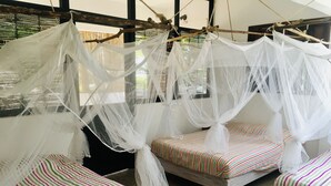Una habitación con dos camas, cada una con dosel y ropa de cama a rayas.