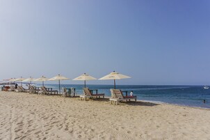 On the beach, white sand, beach umbrellas, beach towels