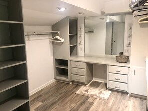 A walk-in closet with open shelving, a large mirror, and a wooden floor. - Mid-Century house in the Trees (Smyrna)
