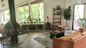 Un salon moderne avec une cheminée, un canapé, une table basse et une bibliothèque.