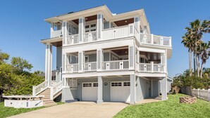 A two-story house with a balcony, a garage, and a well-maintained lawn.
