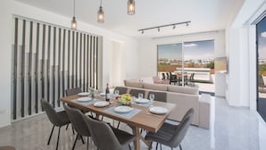 Un comedor moderno con una mesa de madera dispuesta para cuatro personas, rodeada de sillas grises tapizadas.