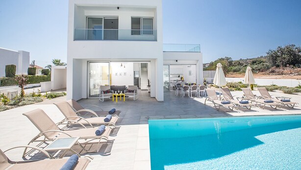 A modern poolside area with lounge chairs and a pool. - The Complete Guide to Renting Your Exclusive Holiday Villa in Protaras with Private Pool and Close to the Beach (Protaras)
