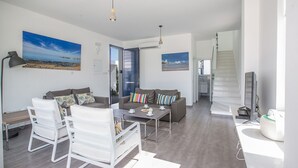 A modern living room with a sofa, chairs, a coffee table, and artwork on the walls. - Protaras Holiday Villa with Private Pool, Protaras Villa 1554 (Protaras)