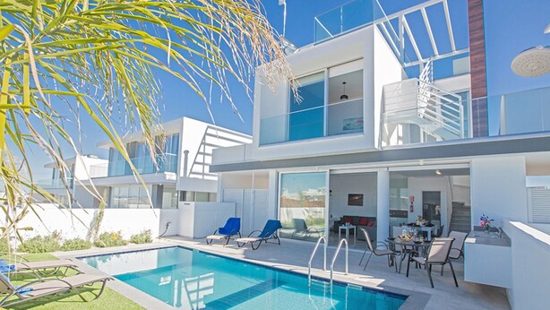 A modern two-story house with a swimming pool, outdoor seating, and a staircase leading to an upper level. - The Ultimate 5 Star Holiday Villa in Protaras with Private Pool and Close to the Beach (Protaras)