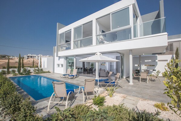 A modern two-story house with a swimming pool, outdoor seating, and a view of the surrounding landscape. - The Ultimate 5 Star Holiday Villa in Protaras with Private Pool and Close to the Beach (Protaras)