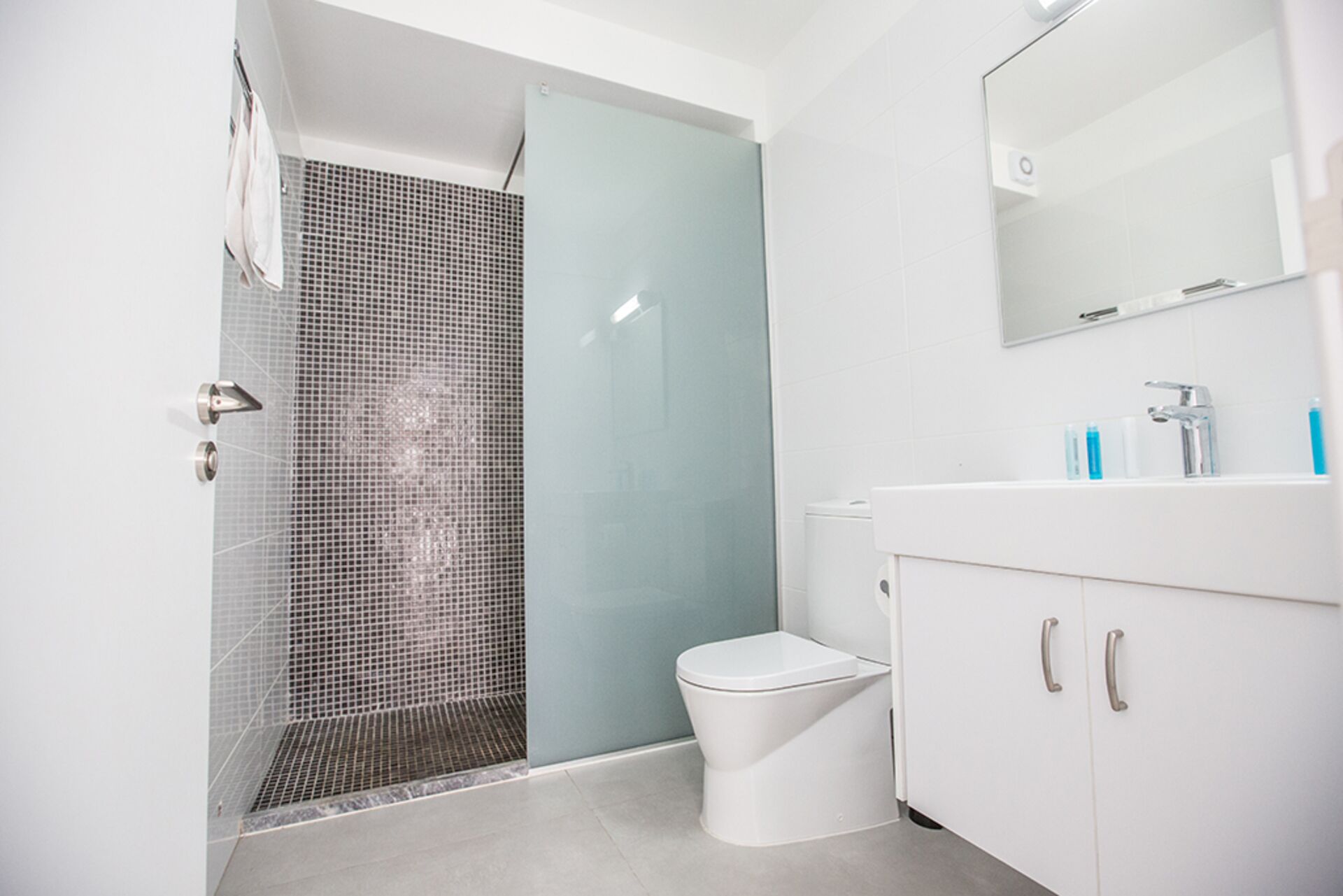 Un baño moderno con ducha, inodoro y tocador.