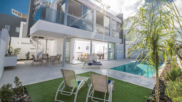 A modern two-story house with a glass facade, a swimming pool, and outdoor seating. - The Ultimate 5 Star Holiday Villa in Protaras with Private Pool and Close to the Beach (Protaras)