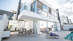 A modern two-story house with a balcony, outdoor seating area, and a swimming pool. - The Ultimate 5 Star Holiday Villa in Protaras with Private Pool and Close to the Beach (Protaras)