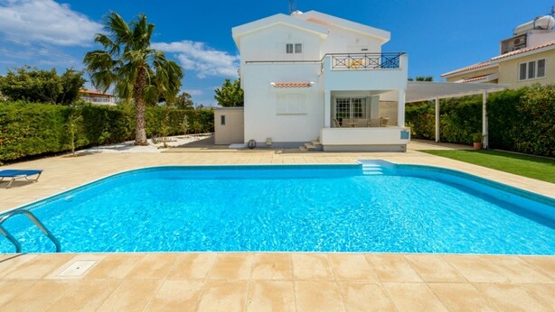 Ein modernes Haus mit Swimmingpool, überdachter Terrasse und gepflegtem Garten.