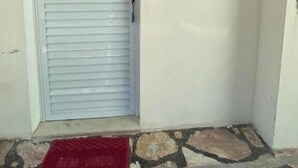 A closed door with the number 211, a small window above it, and a red mat at the entrance. - Loft Vista Mar (Guarapari)